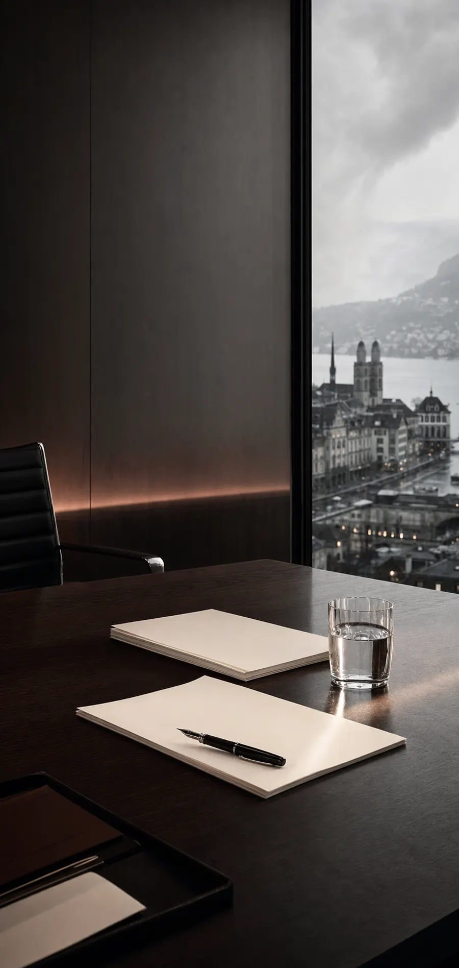 A dark Zurich boardroom overlooking the city, with two document folders and a glass of water on the table.